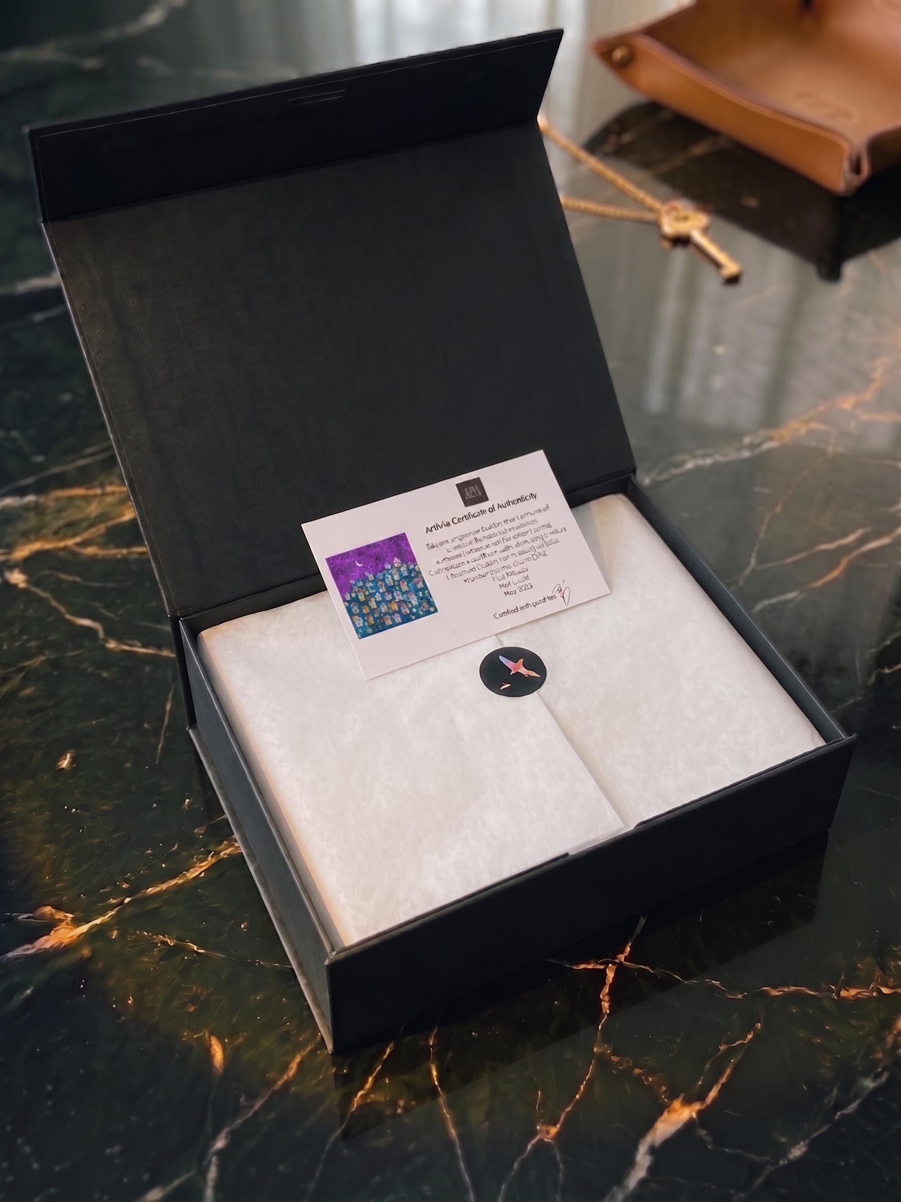An ArtSoie presentation box used to protect and identify a numbered silk edition